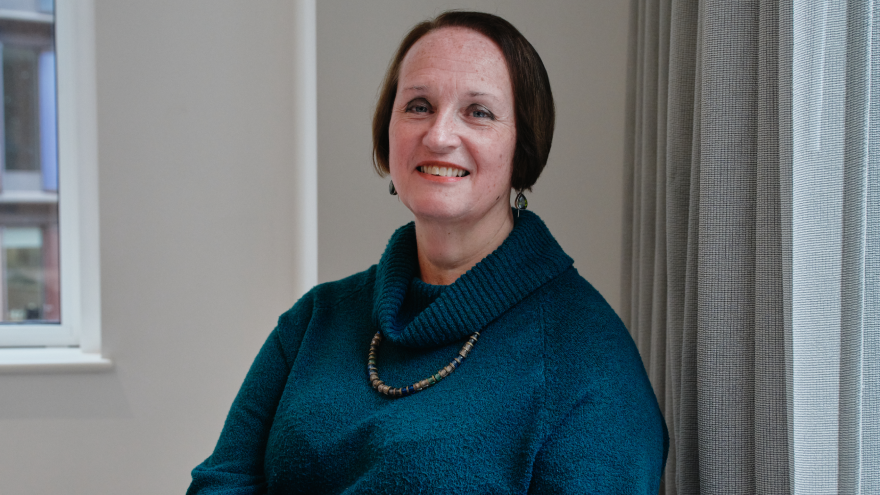 A portrait image of Julia, chair on the board for Mencap Trust Company, smiling at the camera. 
