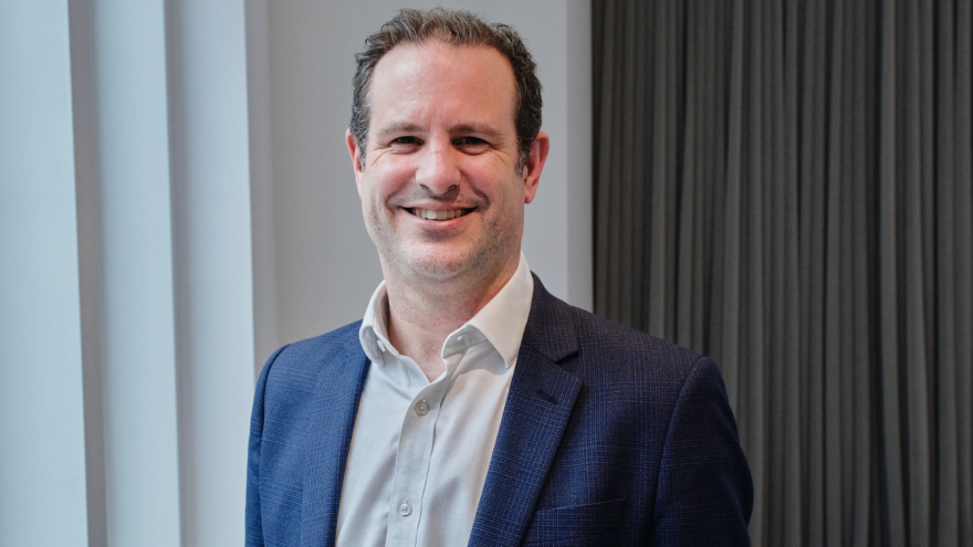 A professional headshot of Paul Grigg who is stood smiling into the camera. 