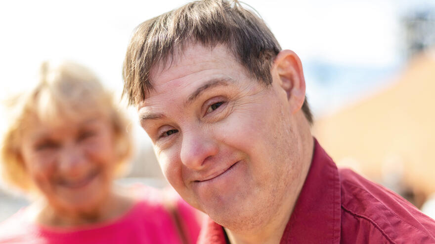 A man looking directly into the camera and is smiling. 