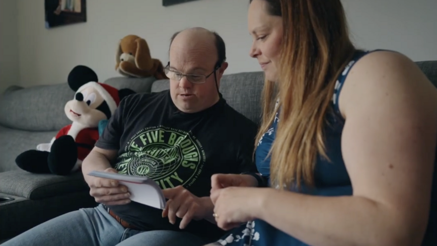 Nick and Stacy sitting on a sofa talking